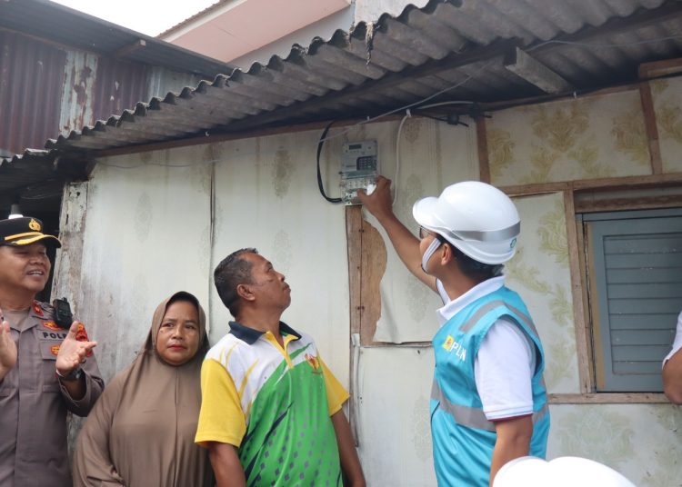 General Manajer PLN UID Sumatera Utara, Ahmad Syauki (tengah) saat melakukan penyalaan listrik yang disaksikan Ade Irwan Nasuition, penerima bantuan Program LUTD.(Satunusantara news/HO-Humas PLN UID Sumut).