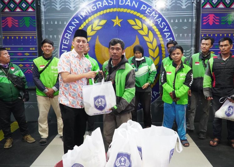 Kepala Rutan Kelas I Medan, Andi Surya (kiri) satat membagikan paket sembako kepada pengemudi ojek online.(Satunusantara news/HO-Rutan Medan).