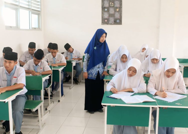 Dra Rosita Fajarwati,S.Pd, Guru Madrasah Aliyah Negeri(MAN) Tanjungbalai (tengah) saat memberikan palajara  kepada siswanya.(Satunusantara news/HO-Kanwil Kemenag Sumut).