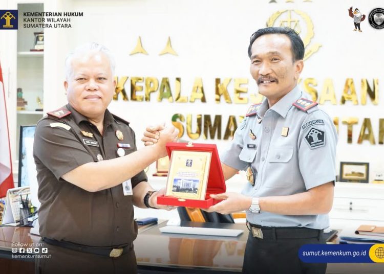 Kakanwil Kemenkum Sumut,  Ignatius Mangantar Tua Silalahi (kanan) saat menyerahkan cendramata kepada Kajati Sumut, Harli Siregar.(Satunusantara news/HO-Kanwil Kemenkum Sumut).