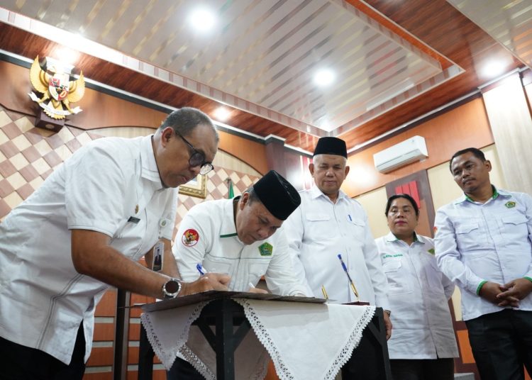 Kakanwil Kemenag Sumut H. Ahmad Qosbi (tengah)  bersama Kepala Dinas Kesehatan Provinsi Sumut H.Muhammad Faisal Hasrimy (kiri) menandatangani MoU pelayanan kesehatan.(Satunusantara news/HO-Kanwil Kemenag Sumut).