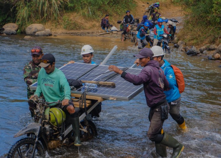 Petugas PLN bersama warga membawa panel surya  melintasi sungai, menjadi bagian dari perjalanan Program Listrik Desa  melalui SuperSUN dalam menghadirkan listrik bagi warga di Kecamatan Seko, Luwu Utara, Sulawesi Selatan.(Satunusantara news/HO-Humas PLN UID Sumut).