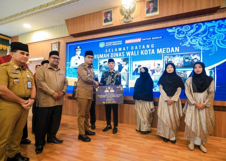 Wali kota Medan Rico Tri Putra Bayu Waas (tiga kiri) saat menyerahkan bonus bagi kafilah Kota Medan pemenang pada STQH XIX tingkat Provinsi Sumut.(Satunusantara news/HO-Diskominfo Medan