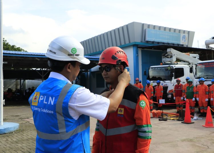 Senior Manajer Distribusi PLN UID Sumut, Hariadi Fitrianto (kiri) saat memasangkan helm kepada peserta apel gabungan di halaman Kantor PLN UP3 Binjai.(Satunusantara news/HO-Humas PLN UID Sumut).