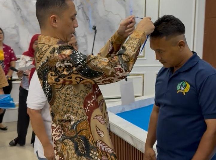 Kepala Rutan Kelas I Medan, Andi Surya (Kiri) saat memasangkan tanda pengenal kepada salah seorang warga  binaan peserta pelatihan  montir sepeda motor di Rutan Medan.(Satunusantara news/HO-Rutan Medan)