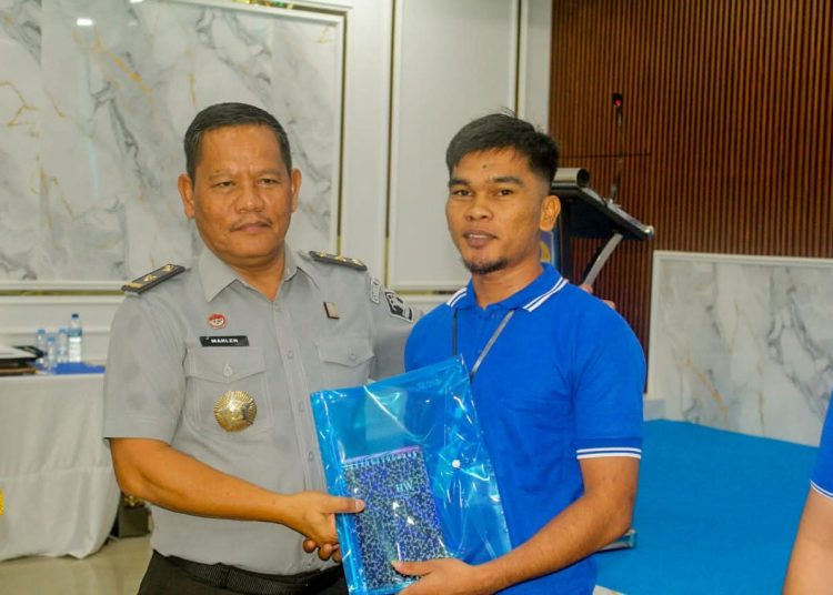 Kadiv Pelayanan Hukum Kanwil Kemenkum Sumut, Sahata Marlen Situngkir, (kiri) saat menyerahkan perlengkapan latihan kepada  warga binaaan di Rutan Kelas I Medan.(Satunusantara newsHO-Kanwil Kemenkum Sumut)