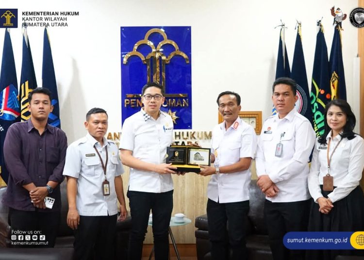 Kakanwil Kemenkum Sumut, Ignatius Mangantar Tua Silalahi (tiga kanan) saat  menyaerahkan cendramata kepada  Anggota DPRD Kota Medan Agus Setiawan. di Kanwil Kemenkum Sumut.(Satunusantara news/HO-Kanwil Kemenkum Sumut).
