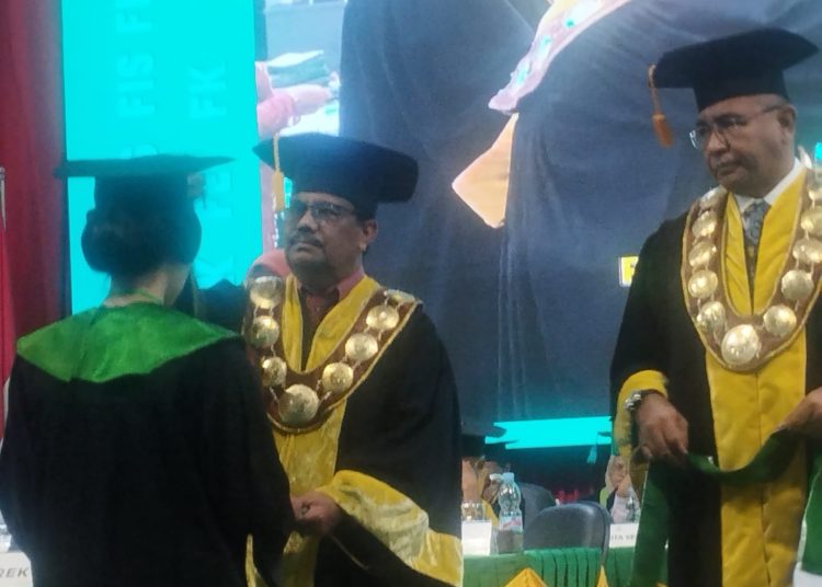 Rektor Unimed Prof. Dr. Baharuddin, ST, M.Pd, saat mewisuda salah seorang wisudawan  periode November 2025 di Auditorium Unimed.(Satunusantara news/Munawar).