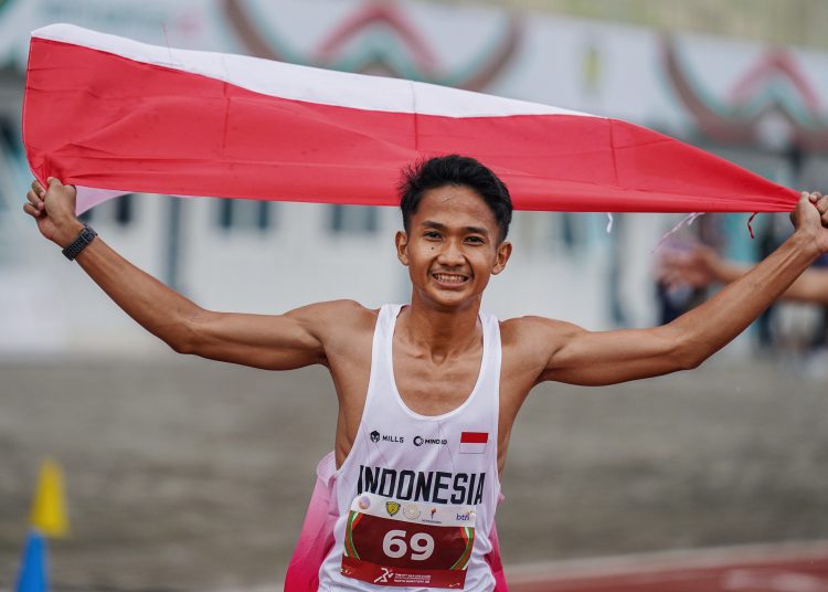 Pelari Indonesia Yap Hapizudin berlari mengibarkan bendera Merah Putih usai memenangkan lomba lari kategori pria 1500 meter U 20 pada event kejuaraan Atletik Asia Tenggara U-18 dan U-20 di Stadion Madya Atletik Kawasan Sport Center Sumut, Kabupaten Deli Serdang, Provinsi Sumatera Utara.(Satunusantara news/HO-Diskominfo Sumut)