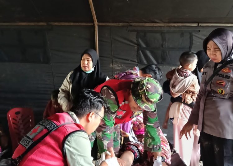 Tim Dukes Kodam I/BB, saat  memberikan bantuan pelayanan kesehatan kepada warga  terdampak banjir bandang di Kabupaten Tapsel.(Satunusantara news/HO-Pendam I/BB)