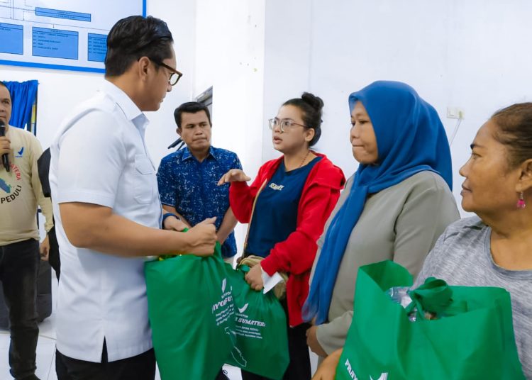 Wali Kota Medan, Rico Tri Putra Bayu Waas (kiri) saat menyerahkan bantuan logidtik kepada warga yang terdampak banjir.(Satunusantara news/HO-Diskominfo Medan).