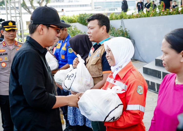 Wali Kota Medan, Rico Tri Putra Bayu Waas (kiri) saat menyerahkan bantuan sembako kepada petugas  kebersihan pada kegiatan bakti sosial yang diselenggarakan Komunitas Mawar Sharon Peduli di Lapangan Merdeka Medan.(Satunusantara news/HO-Diskominfo Medan).