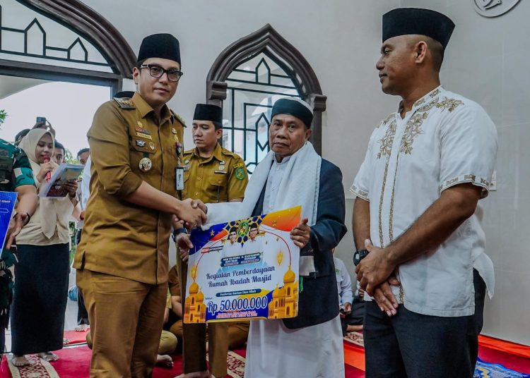 Wali Kota Medan Rico Tri Putra Bayu Waas (kiri) saat menyerahkan bantuan di Masjid Al-Mujahidin Yonko 469 Kopasgat, Kecamatan Medan Polonia.(Satunusantara news/HO-Diskominfo Medan).