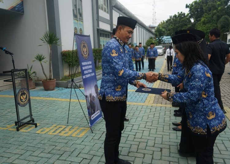Kepala Lapas Kelas I Medan, Fonika Affandi (kiri) saat  menyerahkan bantuan dari Menimipas Agus Andrianto, kepada petugas Lapas Kelas I Medan yang terdampak bencana banjir, pada apel pagi di Lapas Medan.(Satunusantara news/HO-Lapas Medan).