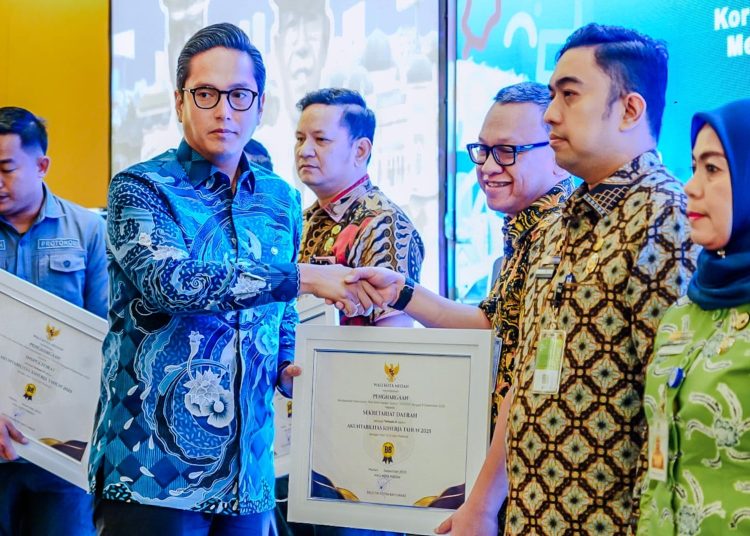 Wali Kota Medan Rico Tri Putra Bayu Waas (kiri) saat menyerahkan penghargaan  pada Peringatan Hari Anti Korupsi Sedunia Kota Medan sekaligus Gelar Wasda Kota Medan Tahun 2025.(Satunusantara news/HO-Diskominfo Medan)