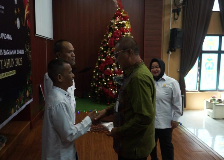 Kepala Kanwil Ditjenpas Sumut, Yudi Suseno (kanan) saat menyerahkan SK Remisi Khusus Natal 2025 kepada salah seorang Narapidana di Gereja Oikumene Lapas Kelas I Medan.(Satunusantara news/HO-Lapas Medan).