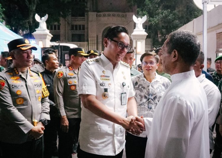 Wali Kota Medan, Rico Tri Putra Bayu Waas (tengah) saat menyalami salah seorang  jemaat gereja pada malam Natal di Kota Medan.(Satunusantara news/HO-Diskominfo Medan).