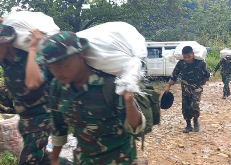 Satgas Kodam I/Bukit Barisan bersama prajurit Yonif TP 905/TS berjalan kaki menyusuri medan berat akibat cuaca buruk untuk menyalurkan bantuan logistik kepada warga di Desa Bonan Dolok, Kecamatan Sitahuis, Kabupaten Tapteng.(Satunusantara news/HO-Pendam I/BB)