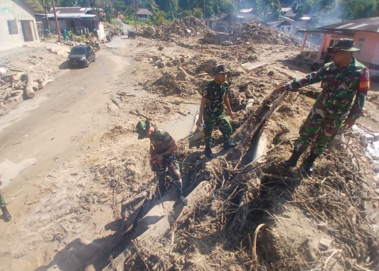Personel Yon TP 905/TS, saat membersihkan lumpur dan material kayu  yang tertumpuk di Jalan Aek Parira, Kelurahan Angin Nauli, Kecamatan Sibolga Utara, Kota Sibolga.(Satunusantara news/HO-Pendam I/BB).