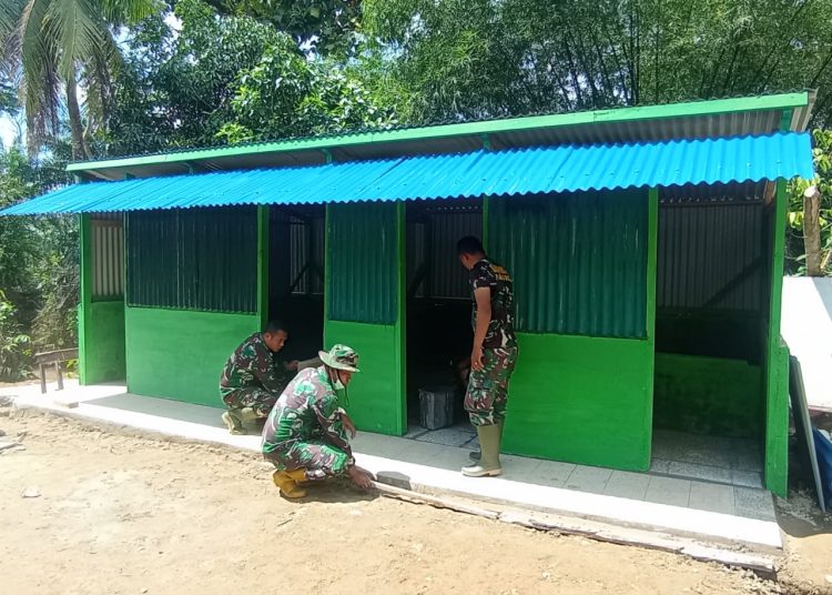 Personel Satgas Koramil 01/Batang Toru, mempercepat pembangunan fasilitas  MCK darurat bagi pengungsi korban banjir bandang di depan SD Desa Aek Ngadol, Kecamatan Batang Toru, Kabupaten  Tapsel.(Satunusantara news/HO-Pendam I/BB).