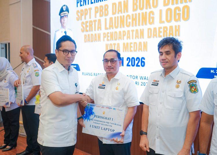 Wali Kota Medan, Rico Tri Putra Bayu Waas (kiri) saat   menyerahkan hadiah kepada Kecamatan dan Kelurahan yang pencapaian realisasi penerimaan PBB tertinggi pada tahun 2025 serta launching logo Bapenda.(Satunusantara news/HO-Diskominfo Medan).