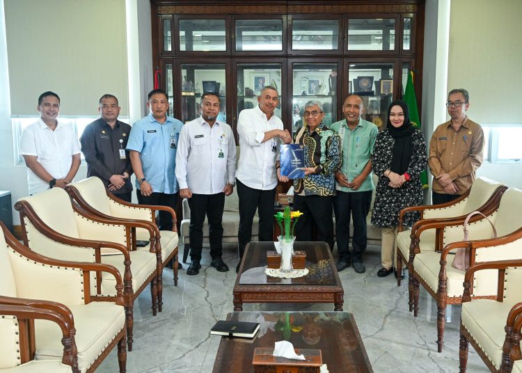 Penjabat Sekdaprov Sumut, Sulaiman Harahap (lima dari kiri) saat menerima laporan kinerja KI Sumut Tahun 2025, diserahkan langsung oleh Ketua KI Sumut Abdul Harris Nasution di Ruang Kerja Sekdaprov, Kantor Gubernur Sumut.(Satunusantara news/HO-Diskominfo Sumut).