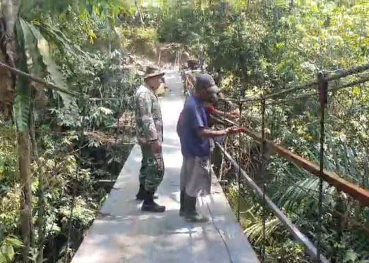 Personel  Kodim 0209/Labuhanbatu, saat  merampungkan rehabilitasi jembatan gantung Sungai Bandar Durian, di Desa Halimbe, Kecamatan Aek Natas, Kabupaten Labura.(Satunusantara news/HO-Pendam I/BB).