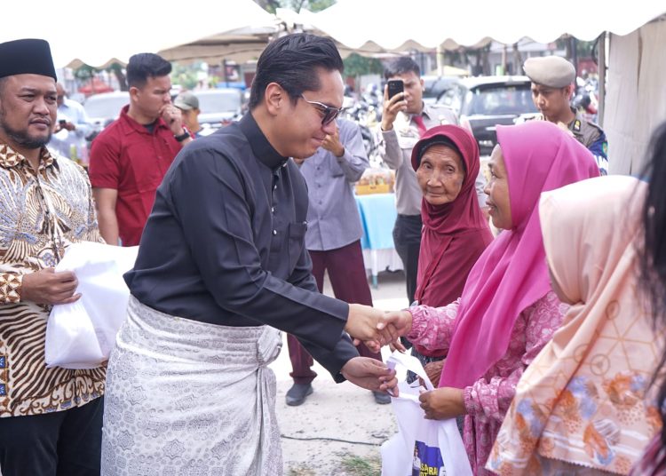 Wali Kota Medan, Rico Tri Putra Bayu Waas (kiri) saat menyerahkan sembako kepada warga yang kurang  saat membuka Pasar Murah Pemko Medan dalam rangka menyambut Bulan Suci Ramadhan dan Hari Raya Idulfitri 1447 H, di lapangan Warna Warni Martubung, Kecamatan  Medan Labuhan.(Satunusantara news/HO-Diskominfo Medan