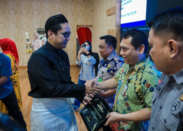 Wali Kota Medan, Rico Tri Putra Bayu Waas (kiri) saat menyerahkan piagam penghargaan kepada Kadis Kominfo, Arrahmaan Pane  di gedung serbaguna PKK, Medan Petisah.(Satunusantara news/HO-Diskominfo Medan).