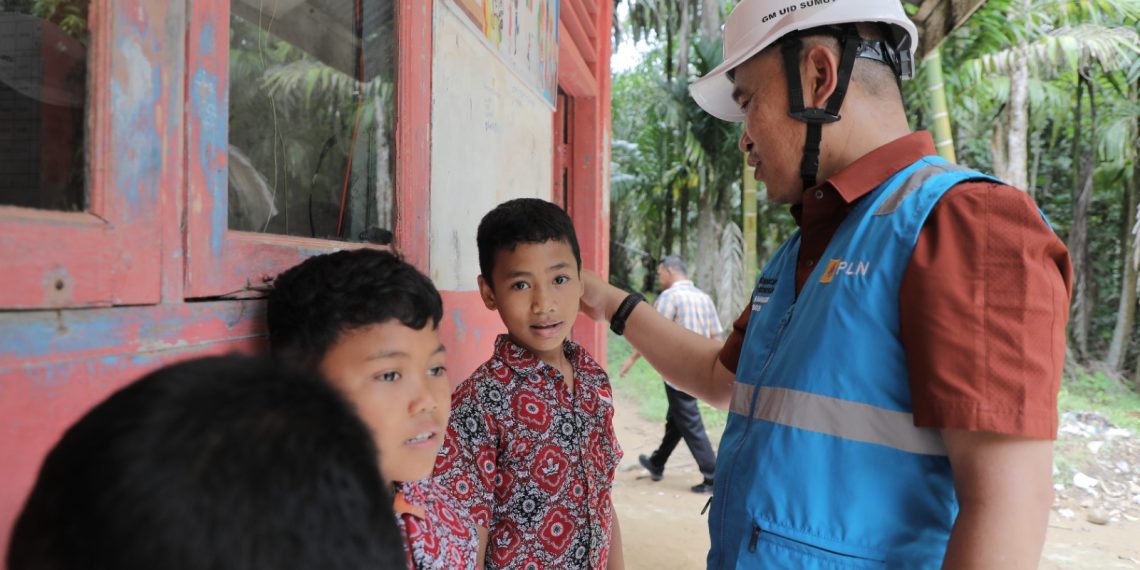 General Manajer PLN UID Sumut,Mundhakir (kanan) saat menyapa siswa di Sekolah Dasar di Desa Unte Makmur, Kecamatan Kolang, Kabupaten Tapanuli Tengah.(Satunusantara news/Humas PLN UID Sumut).