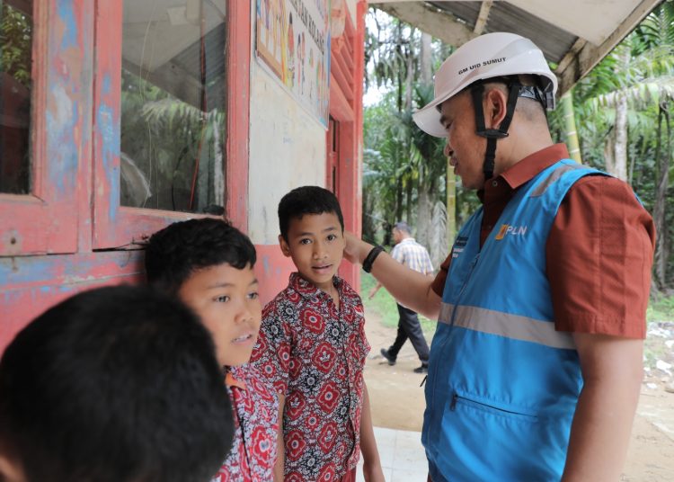 General Manajer PLN UID Sumut,Mundhakir (kanan) saat menyapa siswa di Sekolah Dasar di Desa Unte Makmur, Kecamatan Kolang, Kabupaten Tapanuli Tengah.(Satunusantara news/Humas PLN UID Sumut).