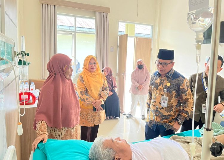 Kakanwil Kemenhaj dan Umroh Sumut, H.Zulkfli Sitorus (kanan) saat menjeguk jemaah haji Muritno (73) dari Desa Sutapranan, Kecamatan Dukuh Turi. Jawa Tengah.(Satunusantara  news/HO-Humas Kanwil Kemenhaj Sumut).