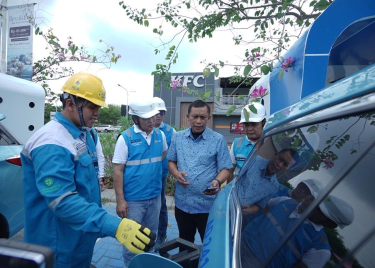 General Manajer PLN UID Sumut, Mundhakir (tenga) saat berbincang dengan pengemudi  taksi mobil listrik yang sedang melakukan pengisian baterai kendaraan.(Satunusantara news/HO-Humas PLIN UID Sumut).