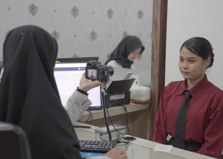 Petugas Imigrasi di wilayah Sumatera Utara (kiri)  saat memberikan  pelayanan pengurusan paspor kepada salah seorang warga masyarakat di kantor Imigrasi.(Satunusantara news/HO-Imigrasi Sumut)