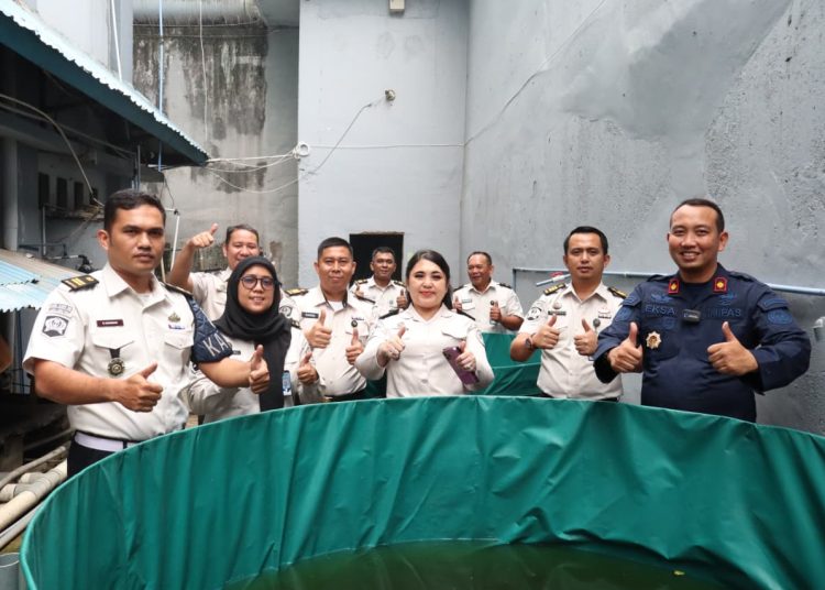 Kepala Rutan KelasI Labuhan Deli, Eksa  Rahnujulian (kanan) saat menebarkan bibit ikan nila dan mujair di Rutan Labuhan Deli.(Satunusantara news/HO-Rutan Labuhan Deli).